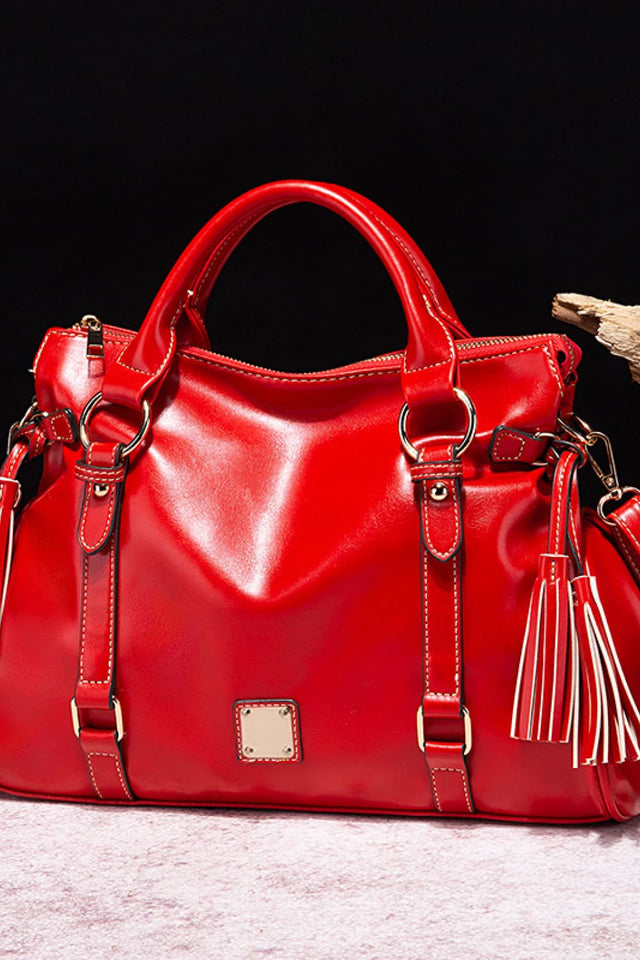 Red handbag with gold accents on a dark background