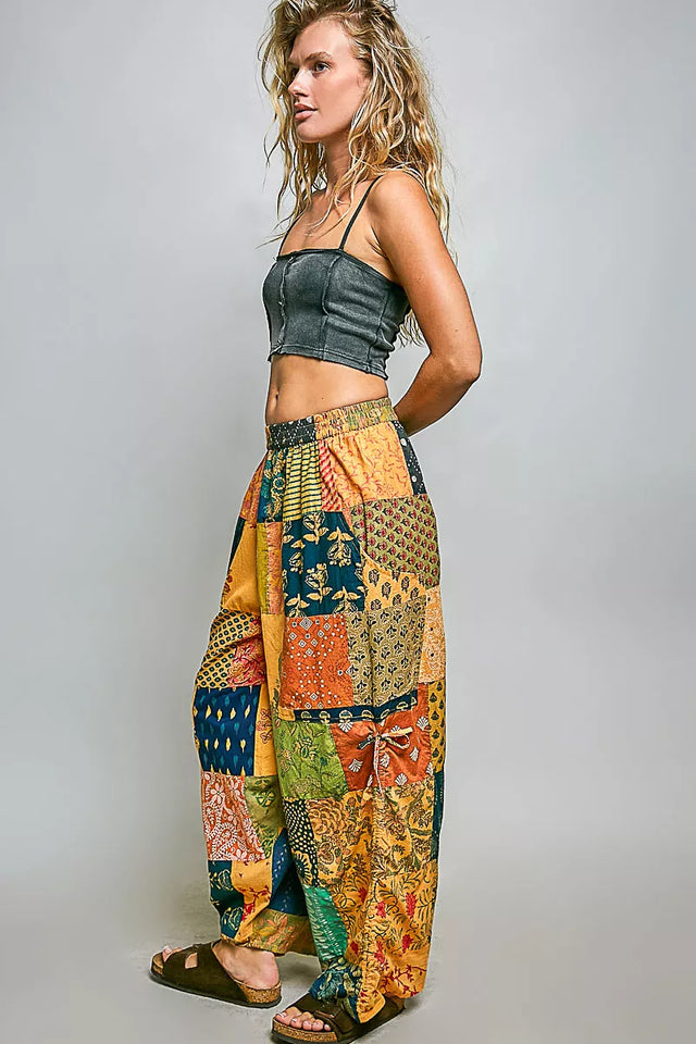 Woman wearing a colorful patchwork skirt on a plain background