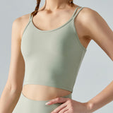 Person wearing a green sports bra and leggings on a gray background