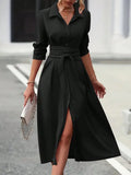 Woman wearing a black dress with a belt, standing on a street.