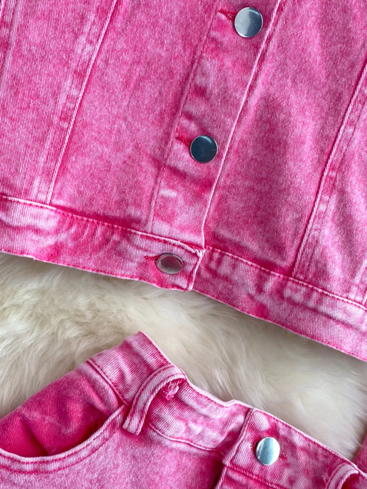 Close-up of a pink denim jacket with buttons on a white background