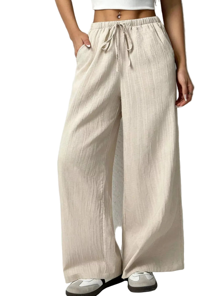 Beige wide-leg pants worn by a person on a white background
