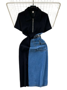 Black top and blue denim skirt set on a textured surface with floral decorations.