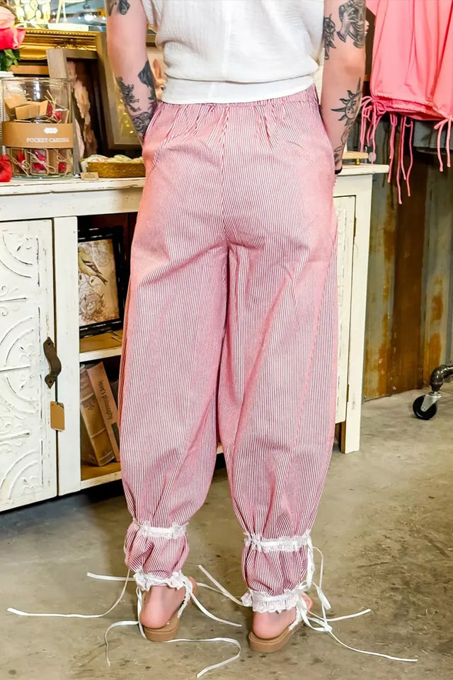 Person wearing pink pants with lace trim in a casual setting
