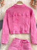 Pink denim jacket and pants on a white fur surface with a blurred background