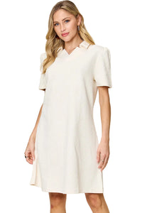 Woman wearing a white dress against a beige background