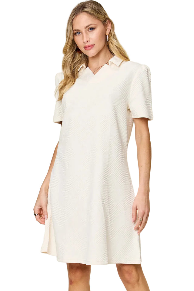 Woman wearing a white dress against a beige background