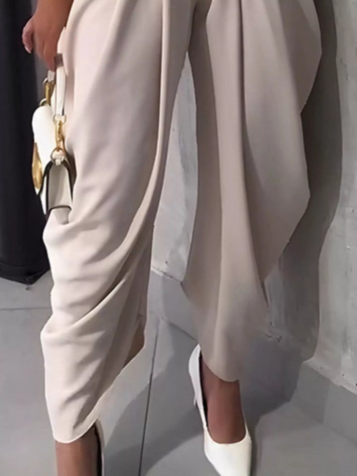 Person wearing a beige dress with a plain background