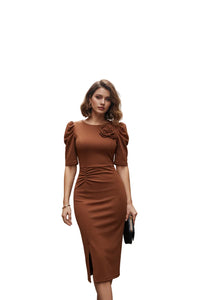 Woman wearing a brown dress with a floral detail in an indoor setting.