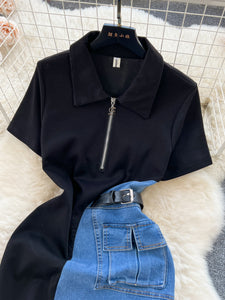 Black long-sleeve top with a zipper and blue jeans on a light background