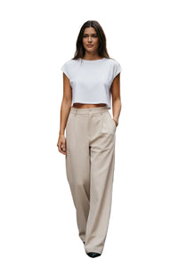 Person wearing beige high-waisted pants on a street.