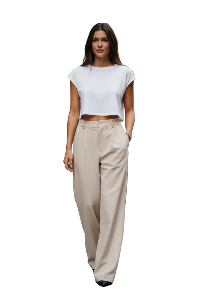 Person wearing beige high-waisted pants on a street.