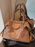 Brown leather handbag with studs on a surface