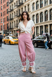 Person wearing pink striped pants with lace trim in a casual setting.