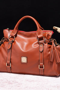 Red handbag with gold accents on a dark background