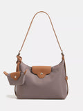 Gray handbag with brown accents on a light gray background