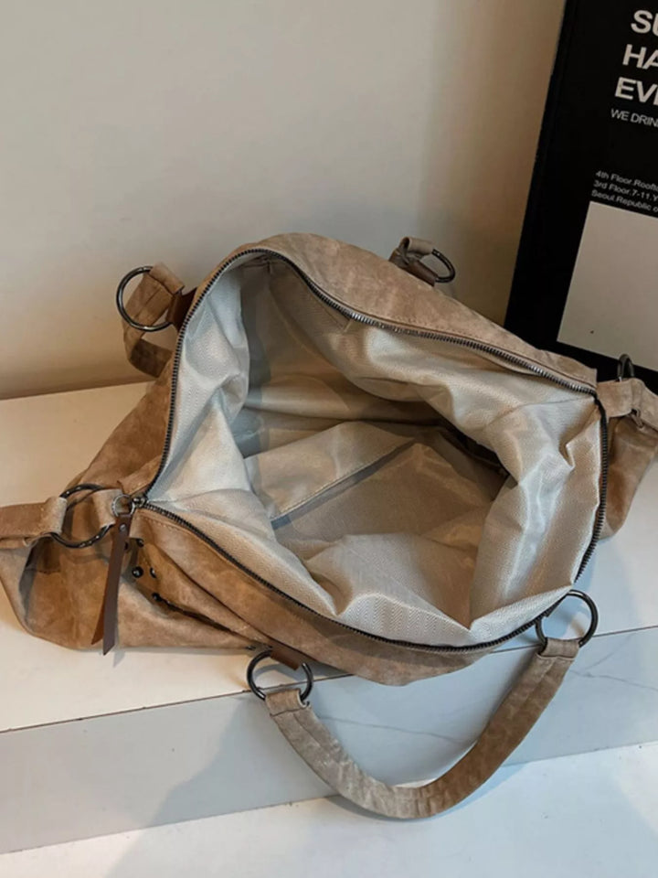 Beige leather bag with a visible brand name on a white surface