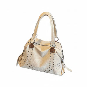 Beige handbag with brown accents held by a person wearing a light gray sweatshirt.