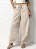 Beige wide-leg pants worn by a person on a white background