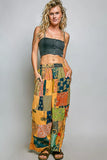 Woman wearing a colorful patchwork skirt and black top on a gray background
