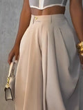 Beige high-waisted pants worn by a person against a gray background
