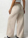Beige wide-leg pants worn by a person on a white background