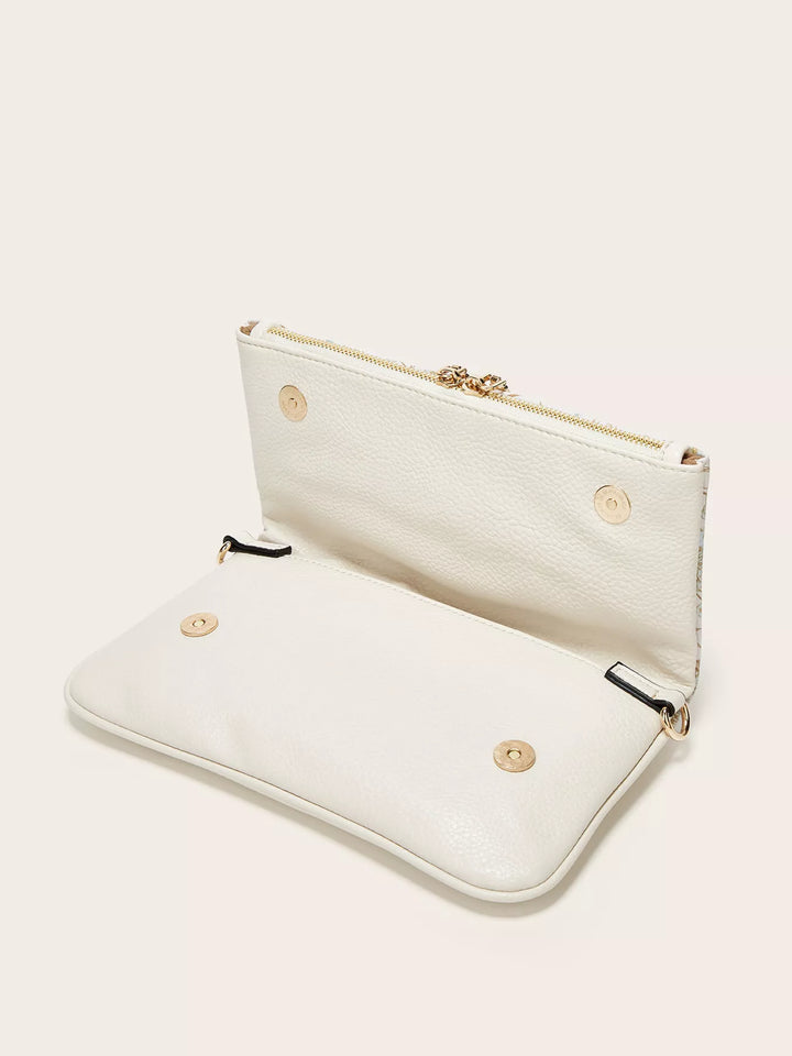 White clutch bag with gold zipper and buttons on a light beige background