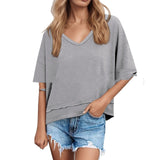 Woman wearing a gray oversized t-shirt and denim shorts on a white background