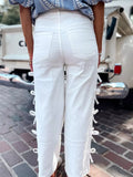 White pants with lace-up details worn by a person, blurred background