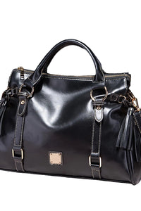 Black leather handbag with gold accents on a dark background