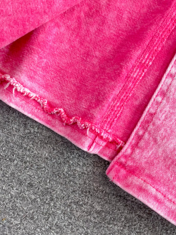 Close-up of pink denim fabric on a gray surface