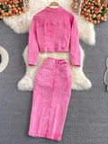 Pink denim jacket and skirt set on a textured surface with floral decorations.