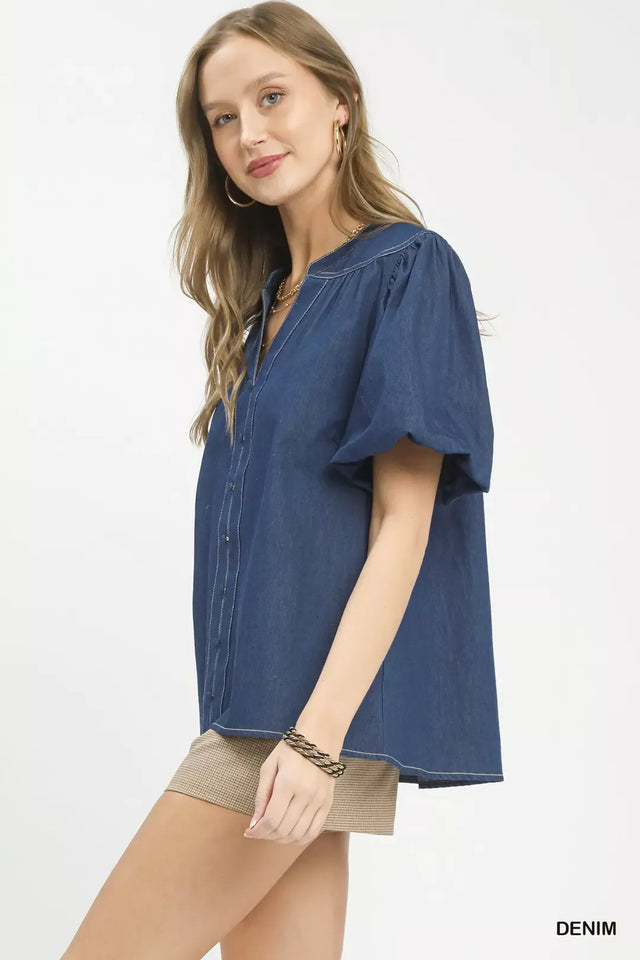Woman wearing a blue denim blouse on a white background