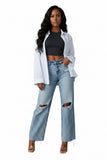 Ripped blue jeans worn by a person on a gray background
