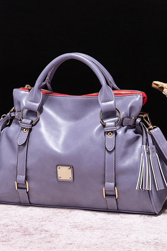 Purple handbag with gold accents on a light gray surface