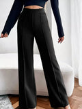 Person wearing black wide-leg pants with a blurred background
