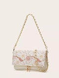 Floral patterned handbag with gold chain strap on a beige background