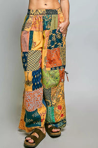 Woman wearing a colorful patchwork skirt and black top on a gray background