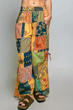 Colorful patchwork pants worn by a person on a gray background