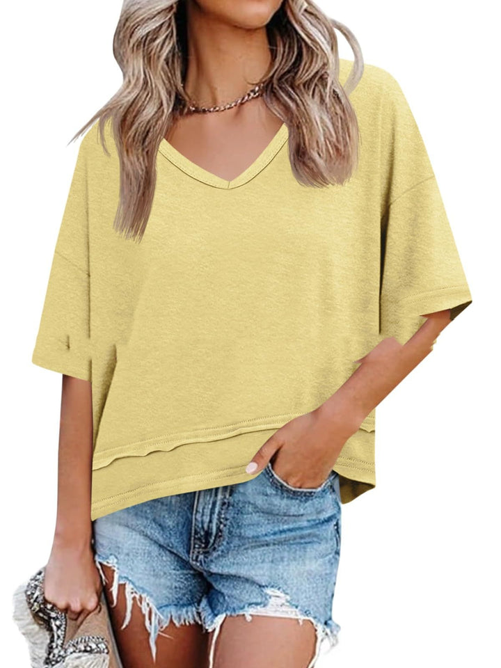 Woman wearing a yellow oversized t-shirt and denim shorts on a white background
