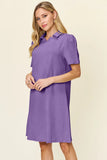Woman wearing a purple dress with a collar on a beige background