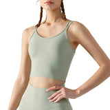 Person wearing a green sports bra and leggings on a white background